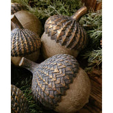 Vintage, rusztikus stílusú, 16 cm hosszú fa hatású, antik arany színnel patinázott karácsonyi makk díszek fenyőágak között